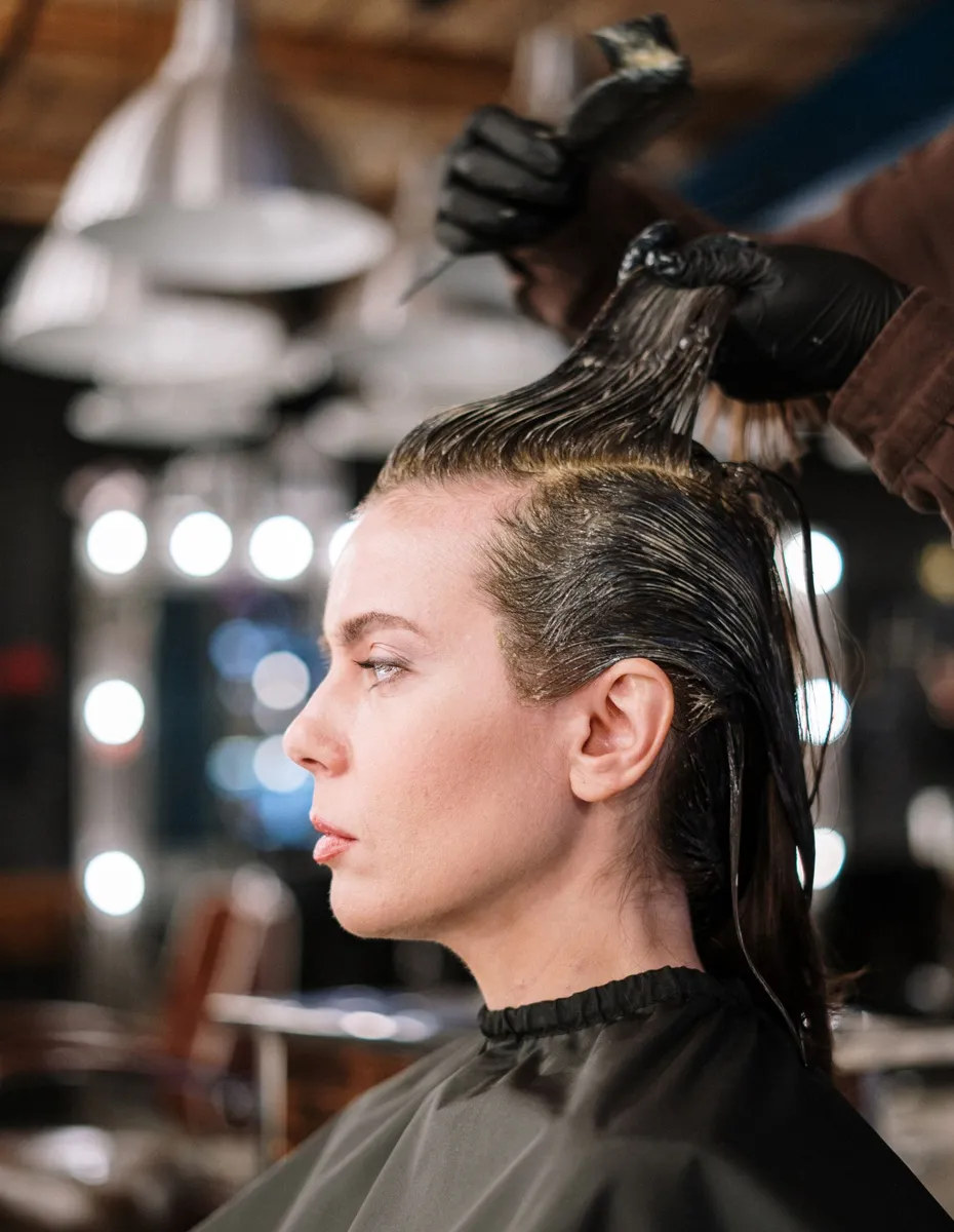 Colourist applying hair colour in a salon